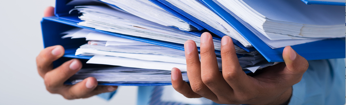 person holding reports in binders