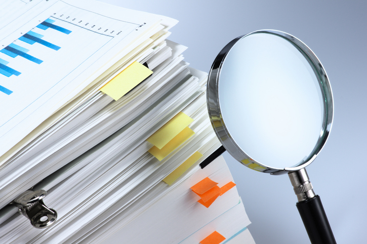 Magnifying Glass And Stack Of Documents